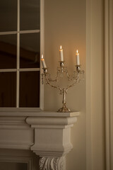 a silver candelabra with a white candles on top of it in a room