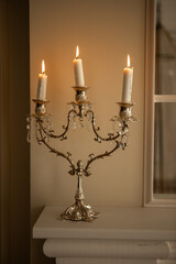 a silver candelabra with a white candles on top of it in a room