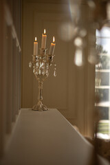 a silver candelabra with a white candles on top of it in a room