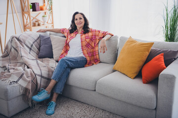 Obraz premium Photo of adorable sweet lady wear plaid shirt smiling relaxing comfortable sofa indoors room home house