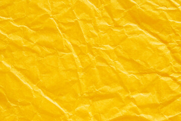 A sheet of wrinkled glossy yellow paper texture as background