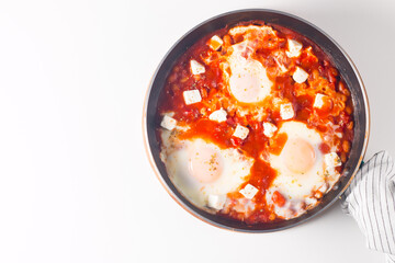 Shakshuka made of poached eggs in tomato pepper sauce