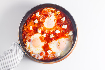Shakshuka made of poached eggs in tomato pepper sauce