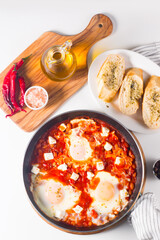 Shakshuka made of poached eggs in tomato pepper sauce