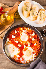 Shakshuka made of poached eggs in tomato pepper sauce