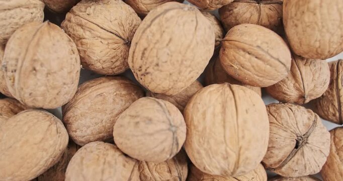 Smooth rotation of wallnuts in shell, top view. Close-up slow motion