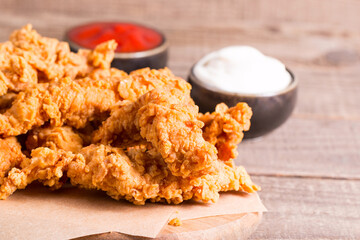Crispy fried chicken breast strips with sauce