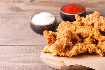 Crispy fried chicken breast strips with sauce