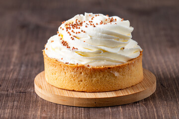 Lemon tartlets with whipped cream, sprinkles and chocolate chips on white background