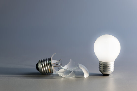 Comparative a broken and a glowing light bulb, old and new idea, failure and success, self development, and learning from mistakes