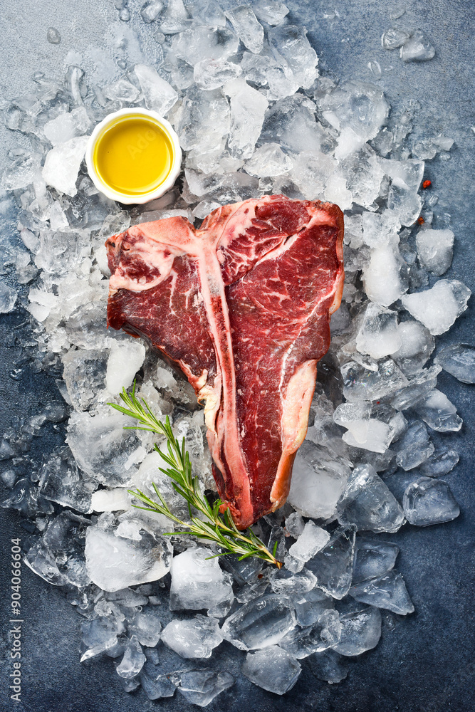 Wall mural aged black angus t-bone steak on ice. close up. top view.