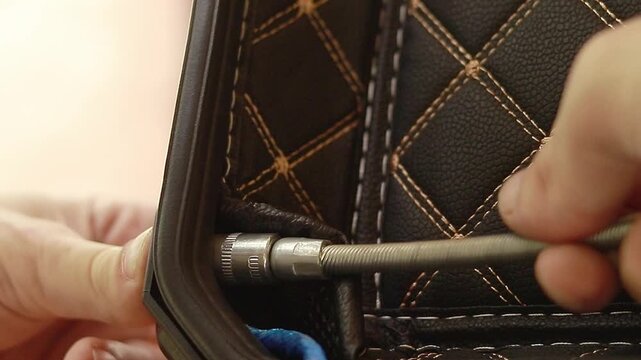 Close up of hands using a hex driver wrench to fit a screw in a hard plastic case
