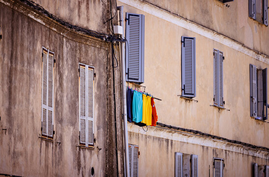Colorful laundry hanging from a window in an old European city. - Powered by Adobe