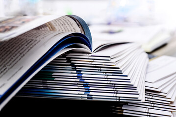 Stack of open books and magazines Focus on a specific point On a white background, isolated