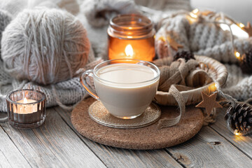 A cozy composition with threads, a candle and a cup of coffee. Hobby and home comfort concept.