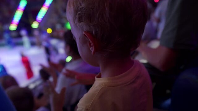 Spectators in a circus. Small child little boy watching a circus performance. Simferopol, Crimea, Russia 2024