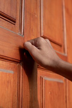 Close up of a man's hand knocking on the door