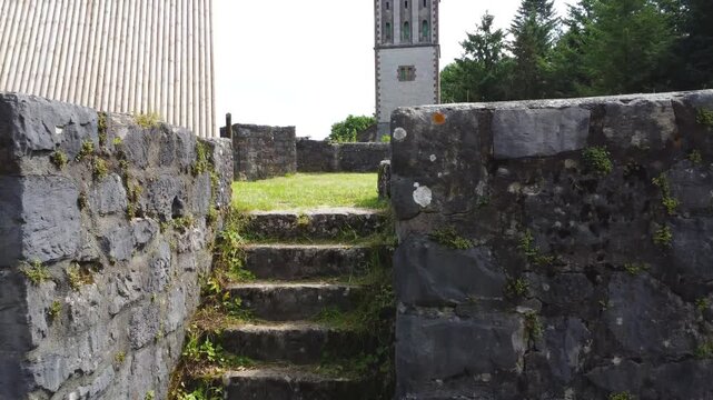 Drohnenaufstieg von Burgruine mit Fokus auf Turm und weitem Blick auf Landschaft und Wald