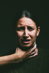 Woman, abuse and strangle with hand in studio for scared, anxiety or victim on dark background...