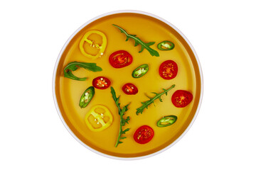 Pattern of vegetable slices on an orange plate isolated on white