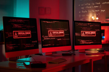 Background image of three computer monitors with emergency messages on screen in red lights copy...