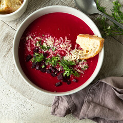 bowl with creamy beet soup on a light table,