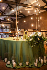 The newlyweds' presidium in the restaurant's banquet hall is decorated with candles and green plants.wedding day