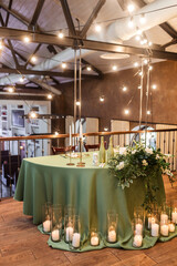 The newlyweds' presidium in the restaurant's banquet hall is decorated with candles and green plants.wedding day