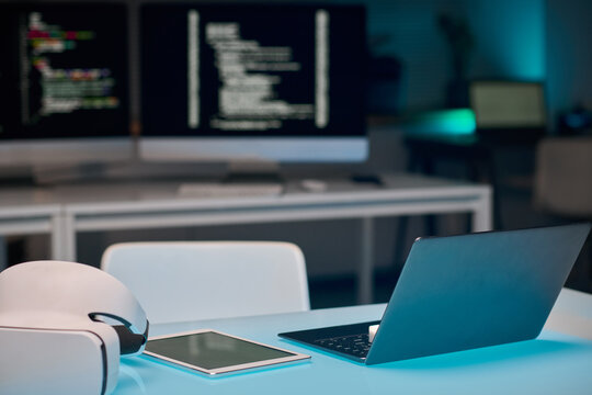 Background image of open laptop at minimal workplace table in IT development office with blue lights, copy space