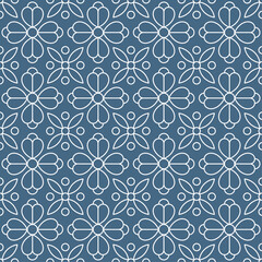 Fototapeta premium Seamless pattern consisting of white lines with floral shapes arranged symmetrically and repeating on a denim blue background. Suitable for textile designs, tiles, wallpapers, backgrounds, etc.