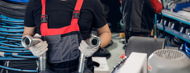 Manufacturing process Worker crimps pressure hydraulic hose with fitting on machine