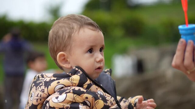 Crian&ccedil;a em um parque brincando com bolhas de sab&atilde;o