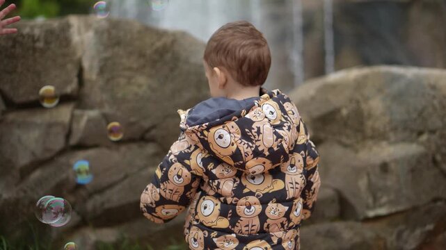 Crian&ccedil;a em um parque brincando com bolhas de sab&atilde;o 
