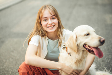 Portrait of teenage girl having fun outside with golden retriever