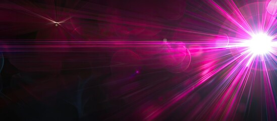 Fototapeta premium Pink lens flare creating an abstract optical effect against a black background with rays of light ideal for a copy space image