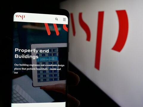 Stuttgart, Germany - 07-21-2024: Person holding cellphone with web page of Canadian consulting company WSP Global Inc. in front of logo. Focus on center of phone display.