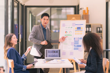 A team of successful Asian business men and women present team meeting minutes and present office collaboration ideas.