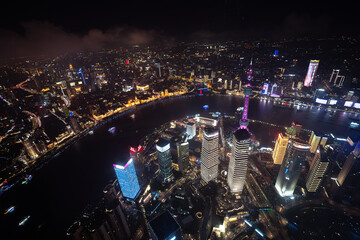 Aerial view of Shanghai city at night with a river in front