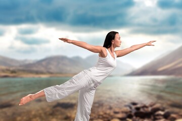 Fototapeta premium Young happy woman practicing yoga outdoor