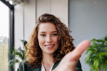 Junge Frau im Büro reicht die Hand