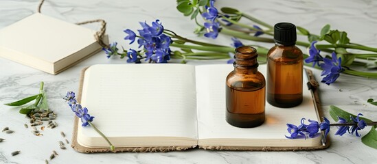 Naturopathic floral healthcare concept featuring bluebell flowers essential oil bottles a notebook and a quill pen on hemp paper with copy space image