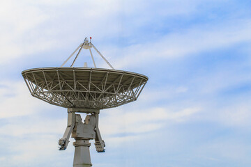 large satellite dish is on top of a pole