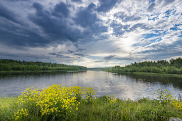 A lake with a cloudy sky in the background