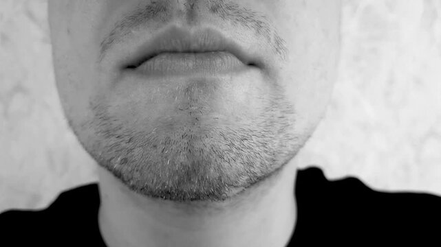A man's mouth taped shut. Peel the tape off the lips. Concept of freedom, of speech, of opinion, of expression.
