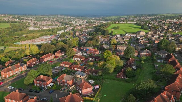 UK city housing: Aerial view of Yorkshire's red brick council estate, bathed in morning sunlight, with a vibrant atmosphere and residents.