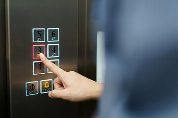 Man choosing a floor in elevator.