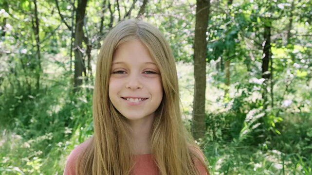 A 10 year old girl with long blonde hair smiles sweetly at the camera.