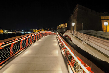 Malta, an illuminated pedestrian bridge, next to which there is a car bridge, connects the two banks of the canal in the Birgu district