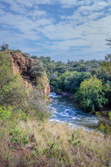 View of a Hennops Hiking Trail, with river running through, small bridge and cableway over the river, Hartbeespoort, Johannesburg, South Africa
