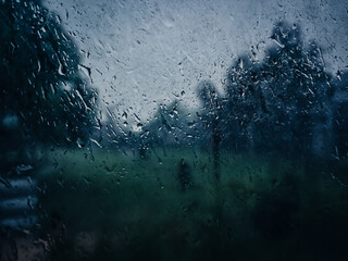 Captured from inside a house during heavy rain season, this image showcases dew drops on the window, creating a beautiful, misty view of the rainy season outside. heavy rain in Kuantan, Malaysia 